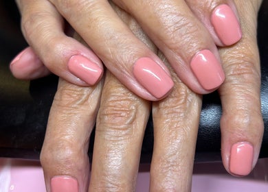 Elegant coral manicure at Rose Dipped Nails, Southampton, England. Perfectly polished nails on display.