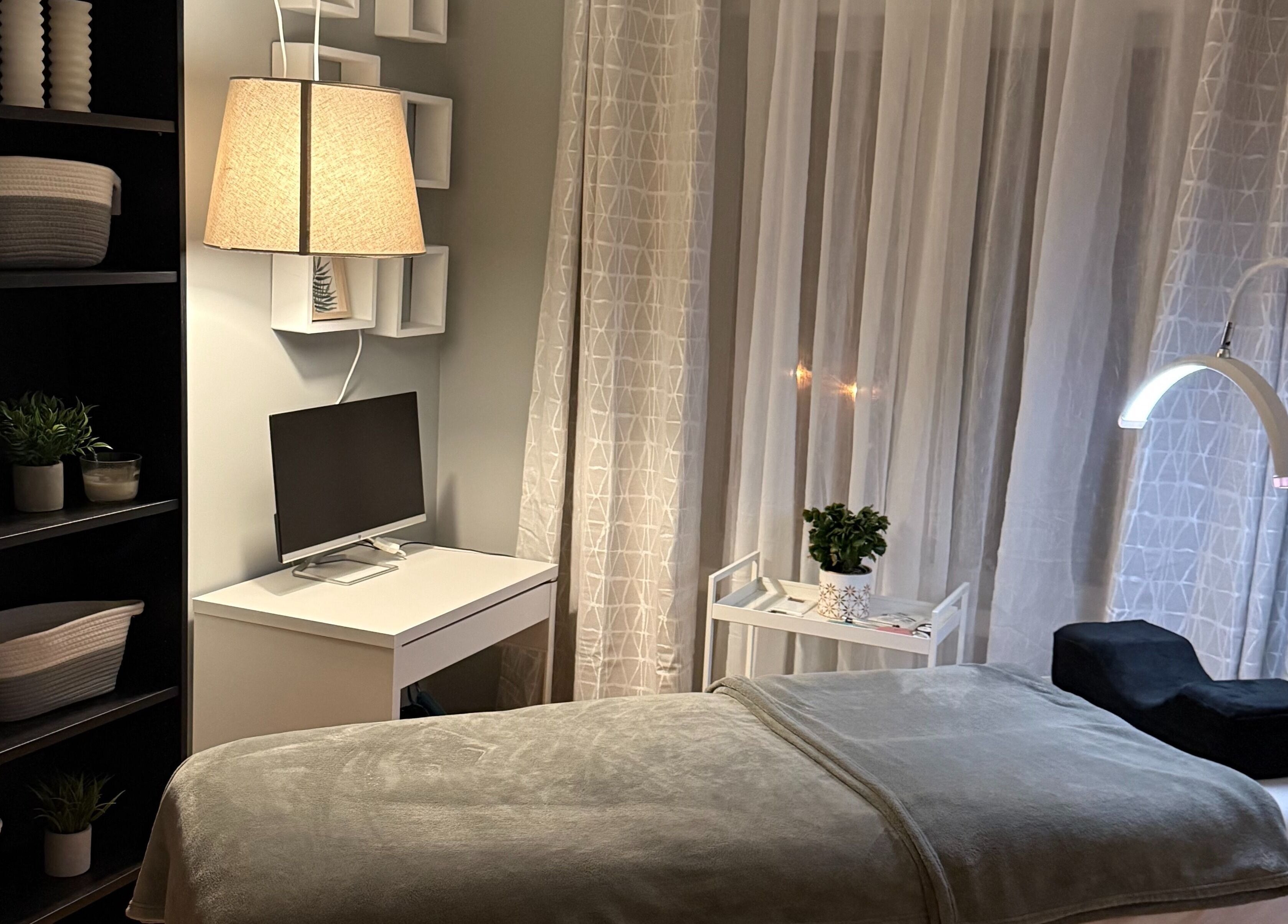 Salle de soins élégante chez Maison Les douces Beautés, Mirabel, Québec, CA, avec table de massage et luminothérapie.
