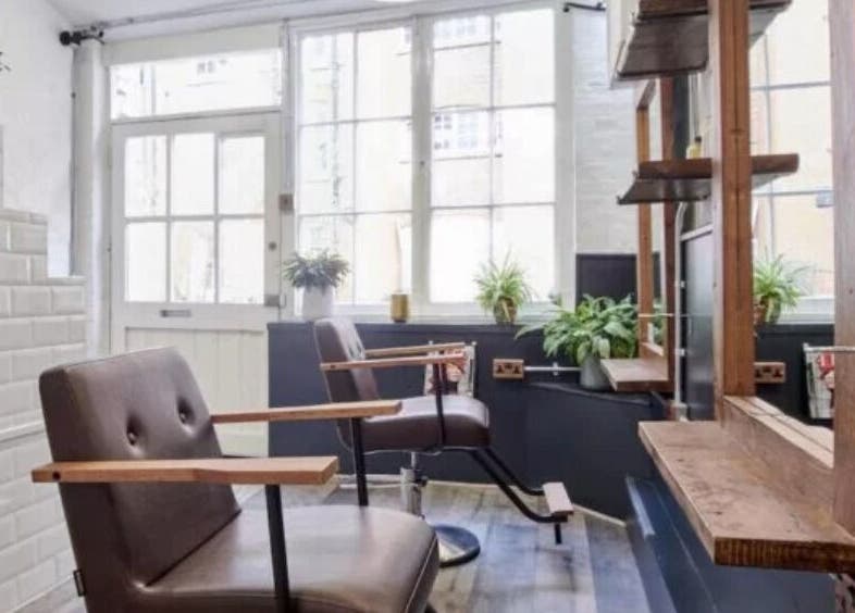 Elegant styling area at Hair by Cristian, London, England, GB with modern chairs and natural lighting.