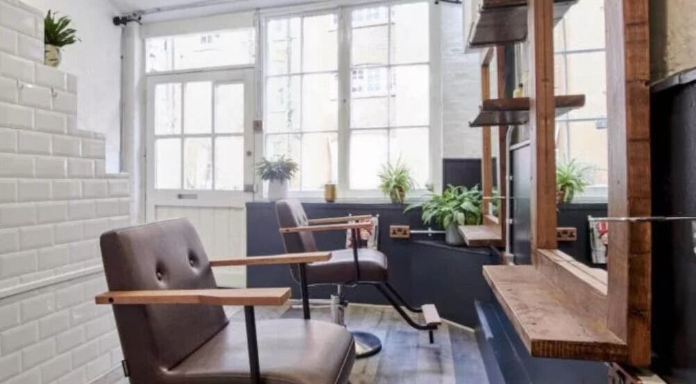 Elegant styling area at Hair by Cristian, London, England, GB with modern chairs and natural lighting.