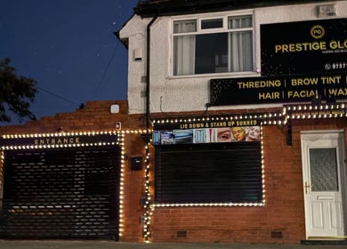 Prestige Glow's illuminated entrance in Bolton, England, GB, showcasing beauty and wellness services.