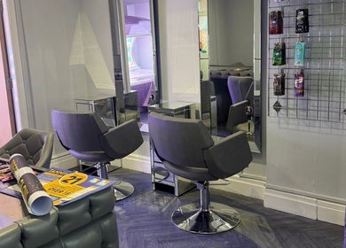 Chic salon interior at Prestige Glow, Bolton, England, GB showcasing stylish seating and mirrors.