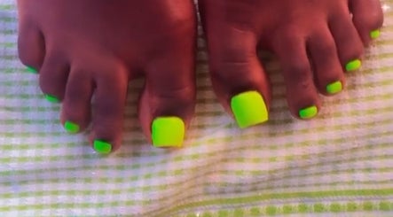 Bright neon green toenails on a checkered towel at The Nail Addict, Bridgetown, Saint Michael, BB.