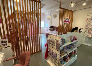 Interior de Beautyland Spa & Accesorios en Buenos Aires, con sillas rosadas y estanterías de productos.