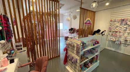 Interior de Beautyland Spa & Accesorios en Buenos Aires, con sillas rosadas y estanterías de productos.