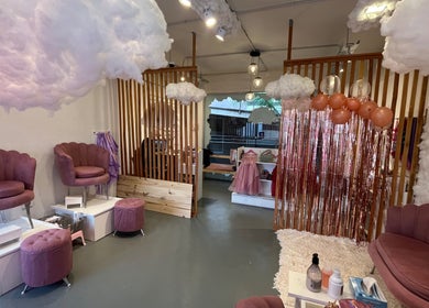 Interior acogedor de Beautyland spa & Accesorios en Buenos Aires, con sillas rosas y decoración de nubes.