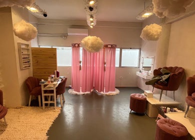 Interior acogedor de Beautyland Spa & Accesorios en Buenos Aires, con sillones rosas y cortinas rosadas.