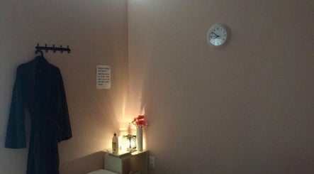 A tranquil treatment room at Symmetry Spa in Seattle, Washington, US with a robe, soft lighting, and decor.