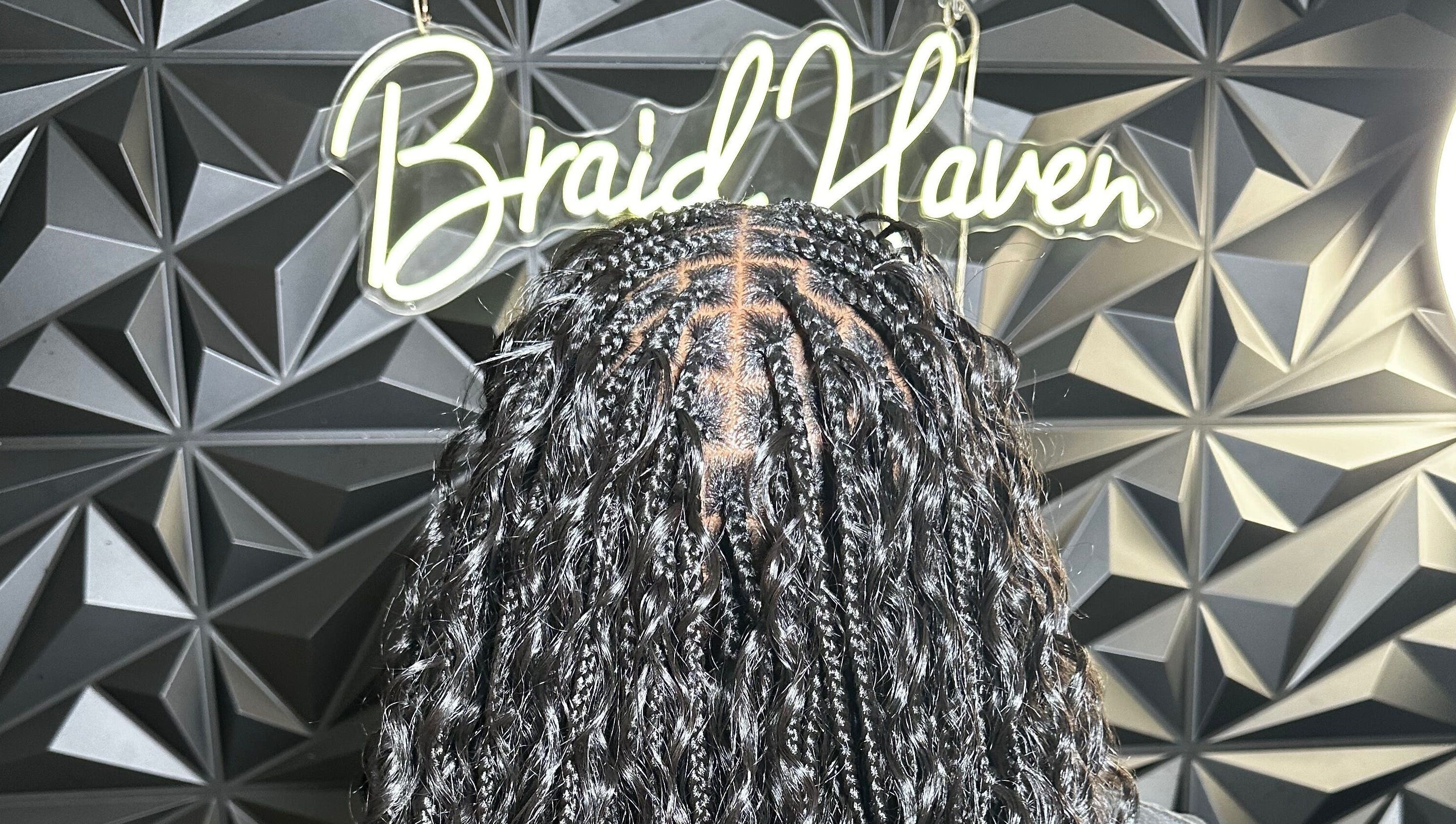 Stylish braids at Braid Haven, Nassau, New Providence, BS, against a chic geometric wall.