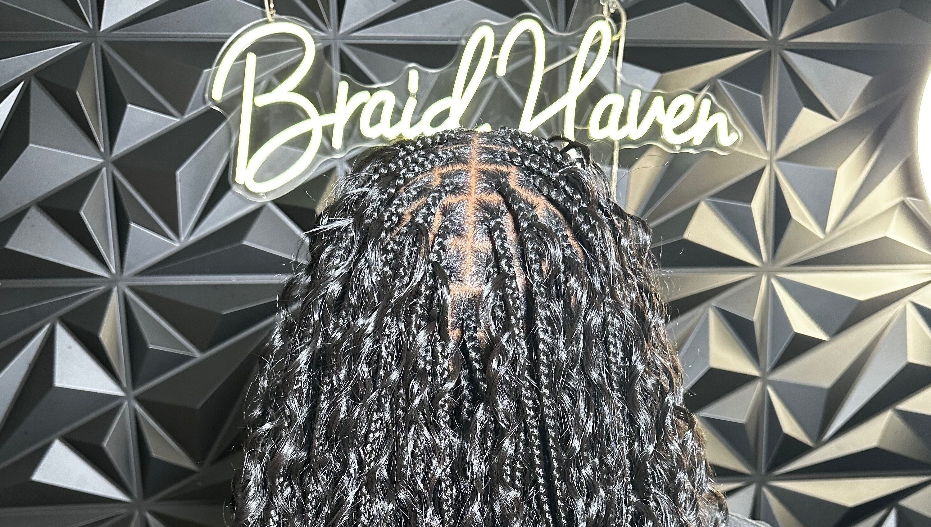 Stylish braids at Braid Haven, Nassau, New Providence, BS, against a chic geometric wall.