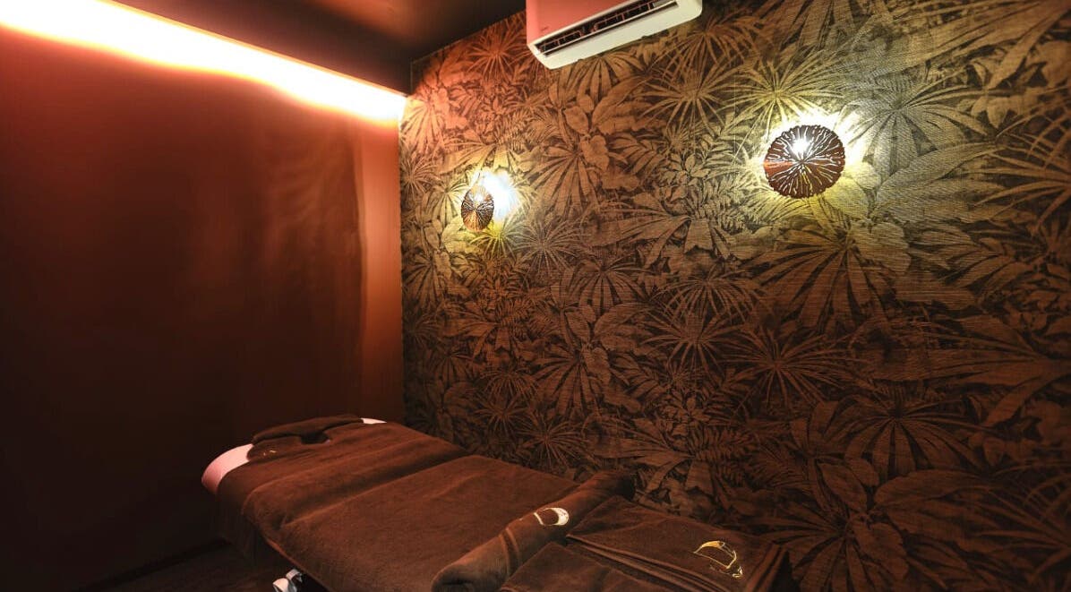 DIVINE HEALTH & MASSAGE 的按摩室，位于九龙九龙，墙面花纹装饰，闪烁温暖灯光。