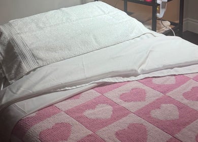 Cozy treatment bed with heart-patterned blanket at The Radiantix Spa in Toronto, Ontario, CA.