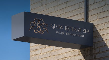 Elegant sign of Glow Retreat Spa - Home Service in Riyadh, Riyadh Province, SA against a brick wall.