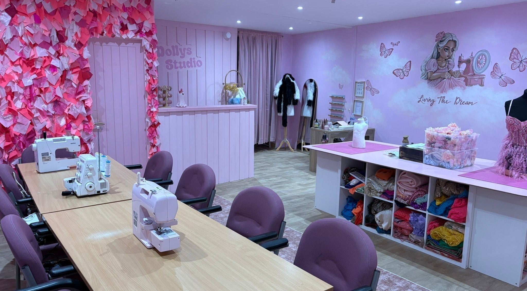 Inside Dolly's Studio in Bradford, England, GB, featuring sewing machines, pink decor, and craft supplies.
