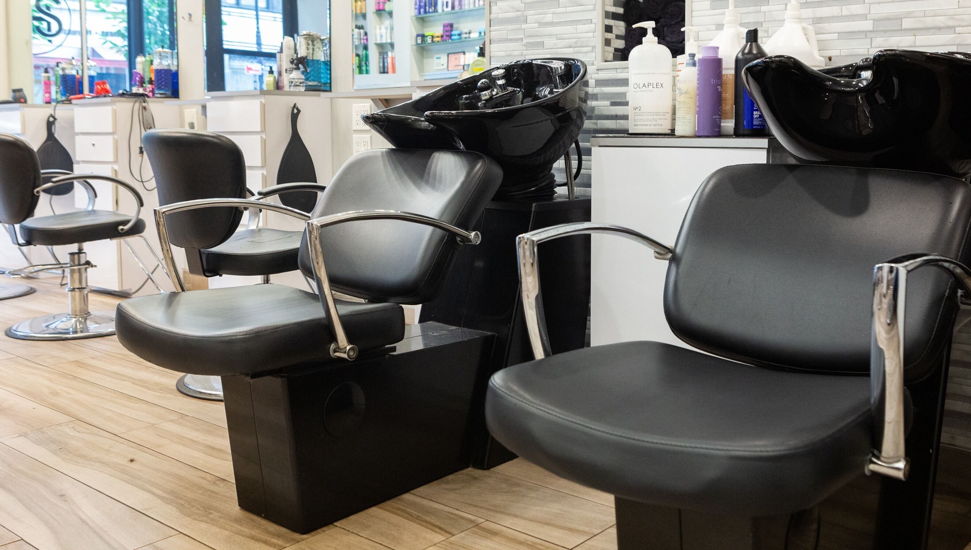 Stylish interior of Tribeca Hair Studio NYC, featuring modern chairs and wash stations. New York, New York, US.