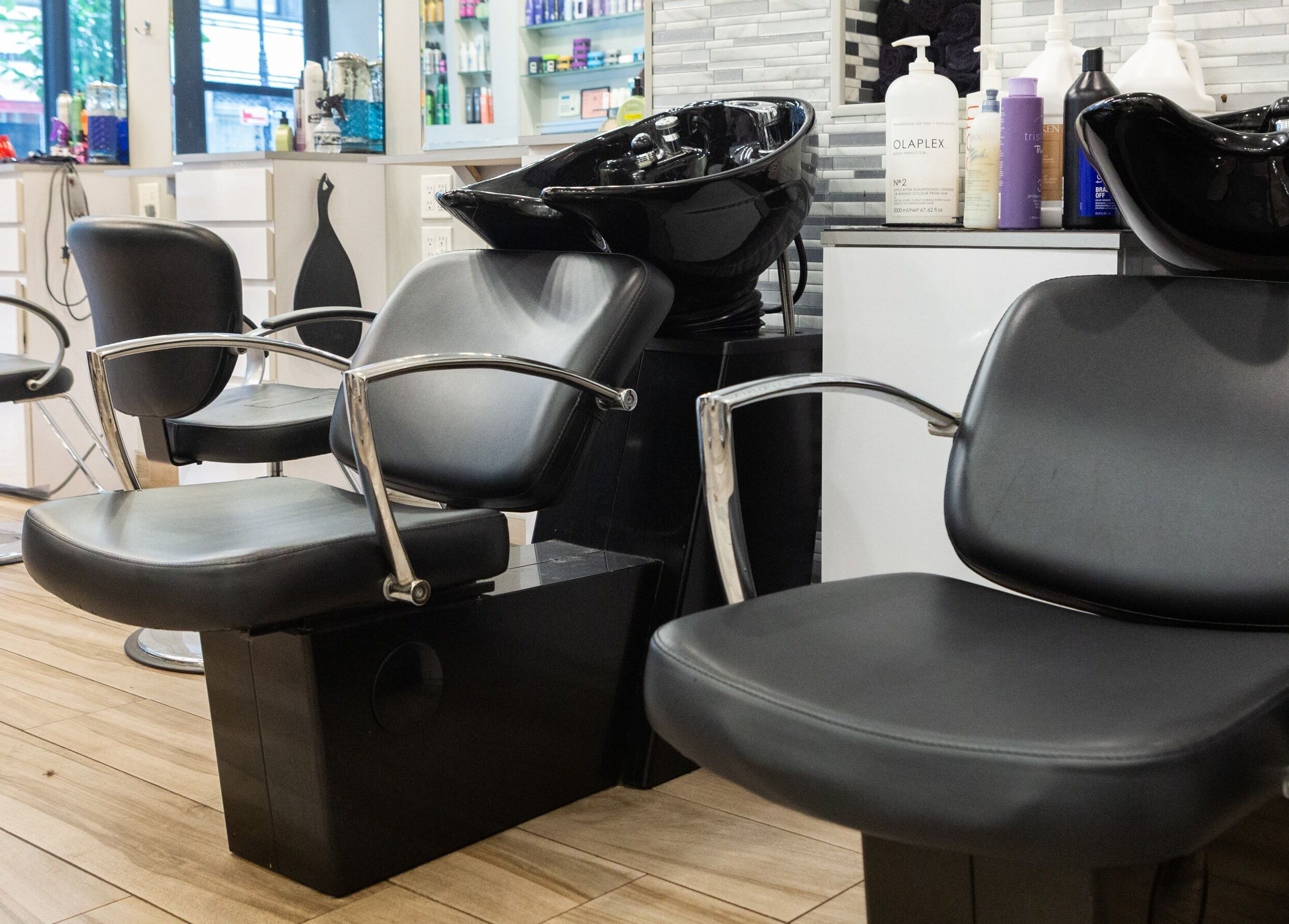 Stylish interior of Tribeca Hair Studio NYC, featuring modern chairs and wash stations. New York, New York, US.