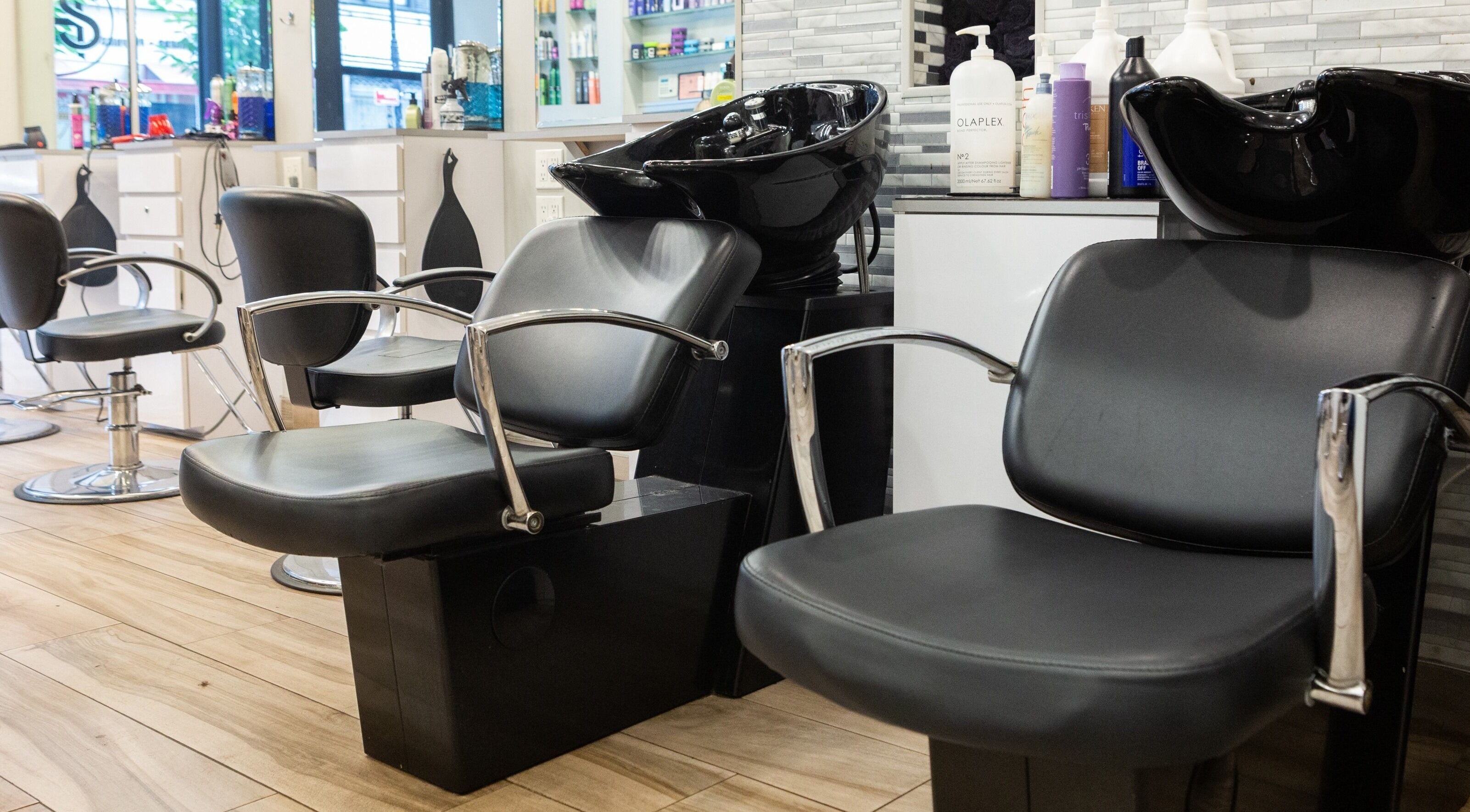 Stylish interior of Tribeca Hair Studio NYC, featuring modern chairs and wash stations. New York, New York, US.