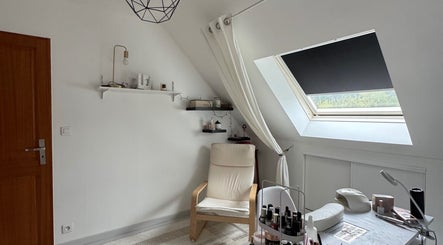 Intérieur lumineux d'Aubree Nails à Épouville, Normandie, avec fauteuil confortable et produits de beauté.