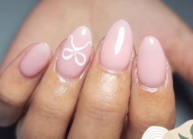 Pastel pink manicured nails with a bow design at Li-Chae Nail Studio, Pretoria, Gauteng, ZA.