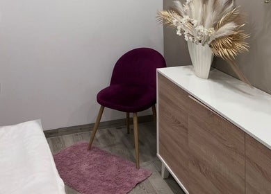 Interior acolhedor no Lumina Beauty Artist em Esposende, Braga, PT, com cadeira roxa e decoração natural.