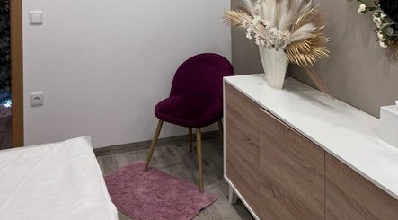 Interior acolhedor no Lumina Beauty Artist em Esposende, Braga, PT, com cadeira roxa e decoração natural.