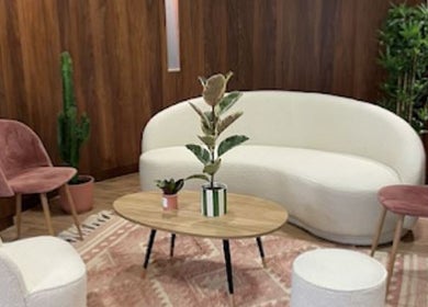 Salon moderne et élégant d'Electraderm à Saint-Denis, Île-de-France, FR avec canapé blanc et chaises roses.