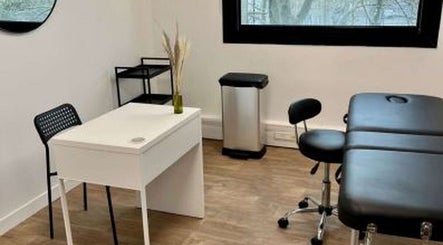 Salle de soin moderne chez Electraderm à Saint-Denis, Île-de-France, FR, avec table de massage et bureau blanc.