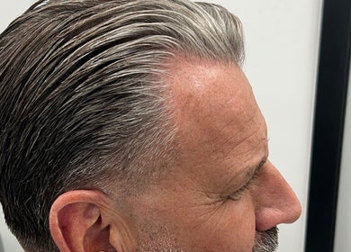 Side profile haircut at Himan mobile barber, Lichfield, England, GB, showcasing sleek grey hair styling.