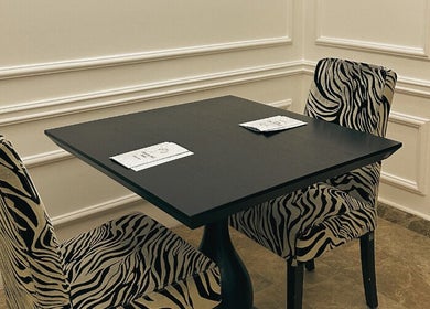 Elegant seating at Wisteria Nail Haus, Abu Dhabi with zebra-pattern chairs in a stylish setting.