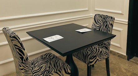Elegant seating at Wisteria Nail Haus, Abu Dhabi with zebra-pattern chairs in a stylish setting.