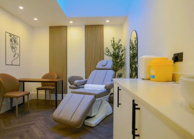 Modern treatment room at Studio Anji Aesthetics, London, England, GB, featuring a plush chair and serene decor.