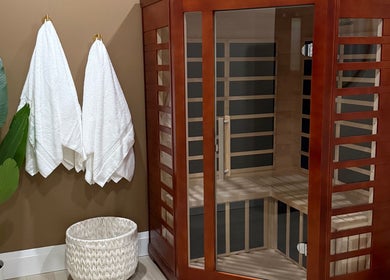 Elegant sauna room at Golden Sweat in London, Ontario, CA with wooden structure and plush towels.