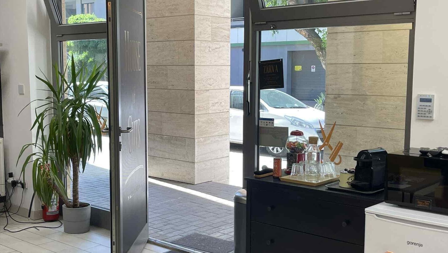 House Of Cuts bejárata Budapest, Magyar, HU. Világos beltér és növények láthatók.