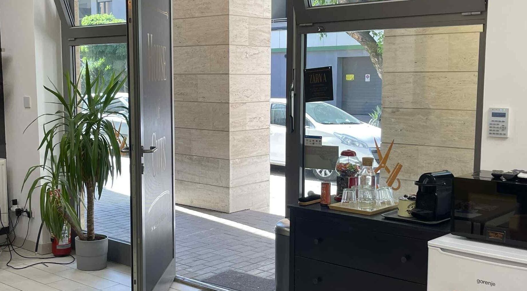 House Of Cuts bejárata Budapest, Magyar, HU. Világos beltér és növények láthatók.