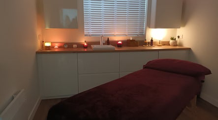 Serene massage room at Velvet Lily Massage, Dunfermline, Scotland, GB with ambient lighting and a massage table.