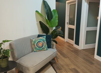 Comfortable seating area at Velvet Lily Massage, Dunfermline, Scotland, with plants and vibrant decor.