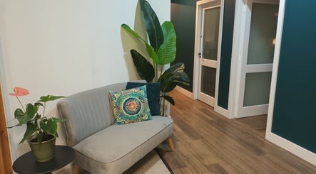 Comfortable seating area at Velvet Lily Massage, Dunfermline, Scotland, with plants and vibrant decor.