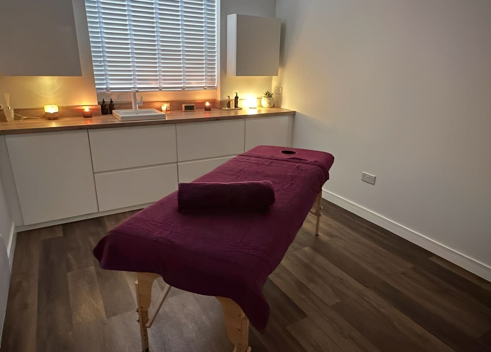 Serene massage room at Velvet Lily Massage, Dunfermline, Scotland, GB, with a cozy table and ambient lighting.