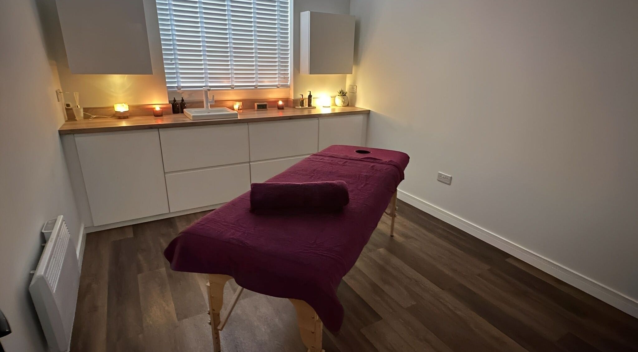 Serene massage room at Velvet Lily Massage, Dunfermline, Scotland, GB, with a cozy table and ambient lighting.