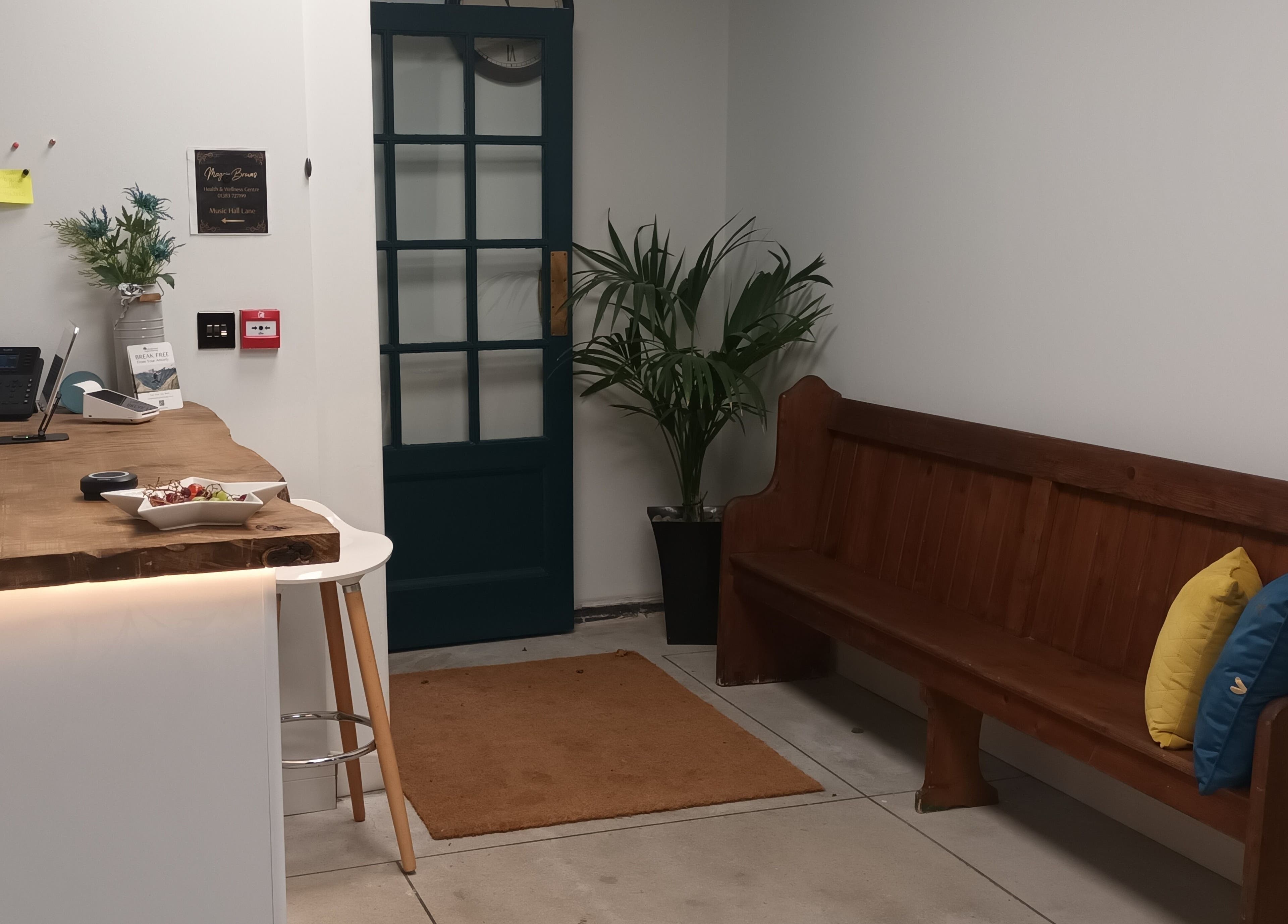 Cozy reception area at Velvet Lily Massage, Dunfermline, Scotland, GB with wooden bench and inviting decor.