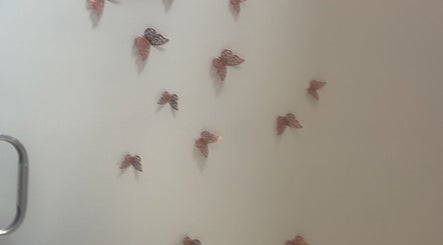Wall adorned with butterfly decor at Luna Glow, Edinburgh, Scotland, GB, enhancing the calming ambiance.