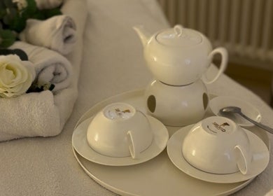 Elegant tea set and plush towels at Ad Astra massage, Trimbach, Solothurn, CH, evoking a serene atmosphere.