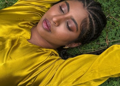 A woman in a golden dress relaxes on grass at For Angels, Dublin, County Dublin, IE.