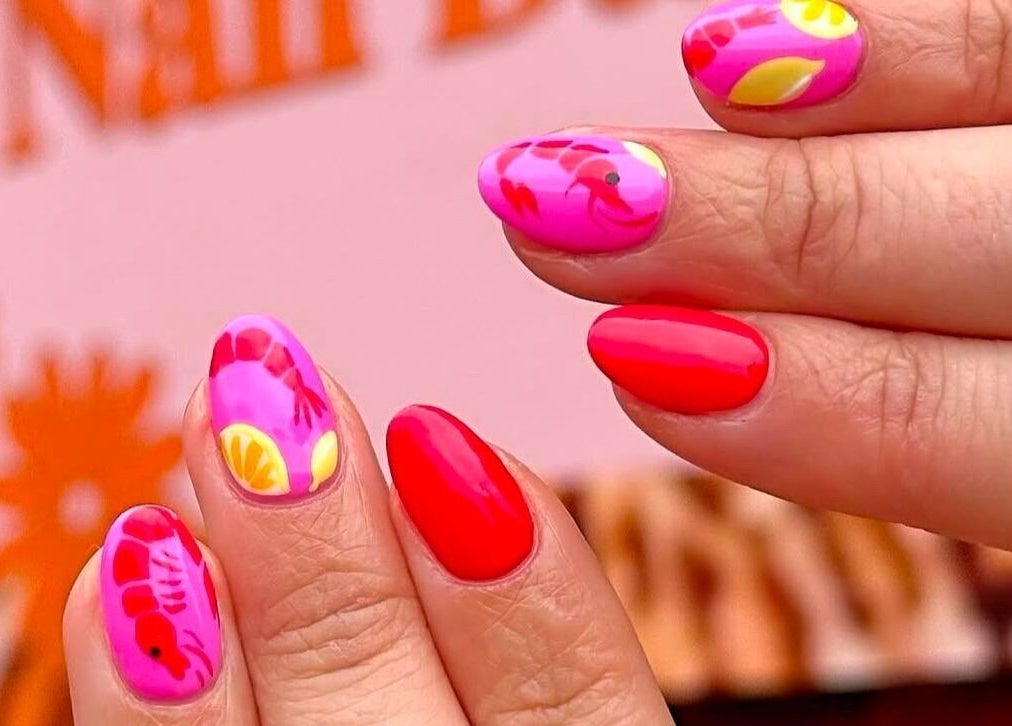 Vibrant nail art at Gorgia Nails, Yate, England, GB, featuring pink and red designs with floral accents.