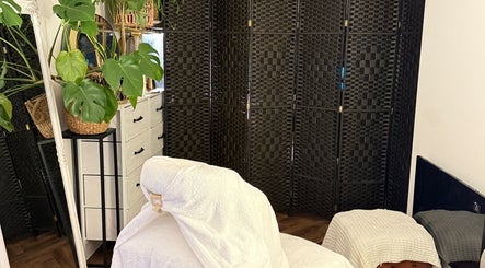 Tranquil massage room at Bloom & Ouud, Birmingham, England, GB with plants and wicker decor.