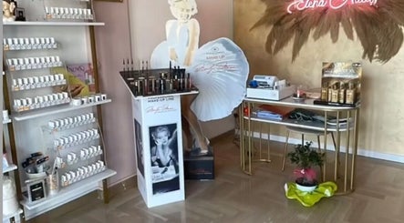 Interno di Elena Nails a Parabita, Puglia, IT con espositori di smalti e decorazioni eleganti.