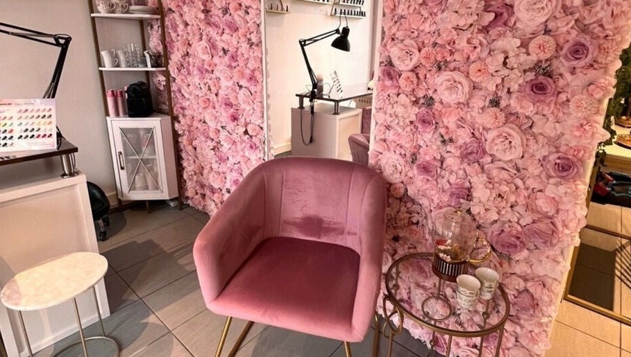 Manilux à Genève, Genève, CH avec un mur de fleurs roses et un fauteuil en velours rose élégant.