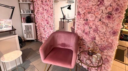 Manilux à Genève, Genève, CH avec un mur de fleurs roses et un fauteuil en velours rose élégant.