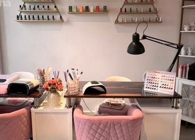 Tables de manucure élégantes chez Manilux, Genève, Genève, CH, avec chaises roses et vernis à ongles.