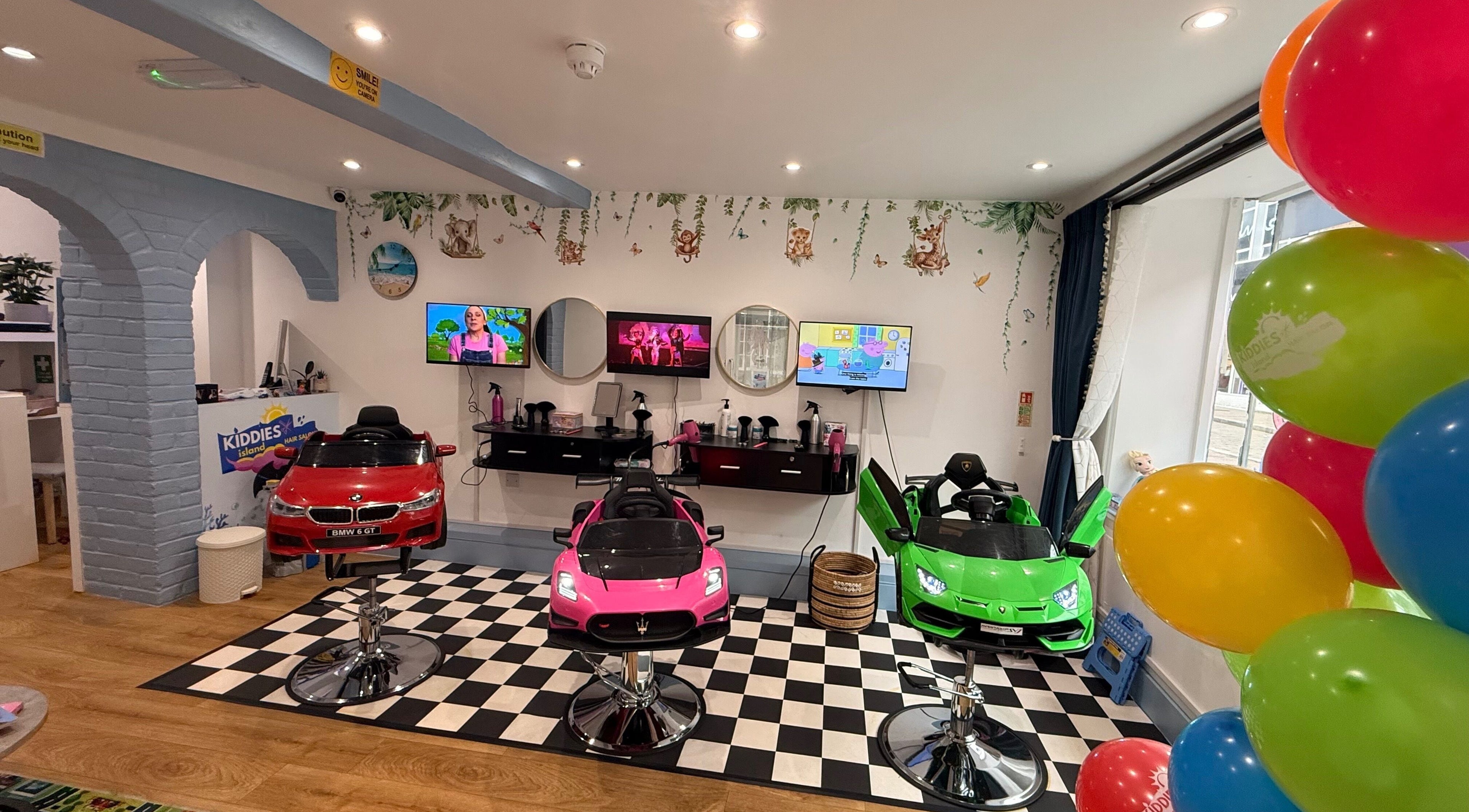 Colorful kids' salon at Kiddies Island Hair Salon LTD, Rickmansworth, England, GB with car-shaped chairs.